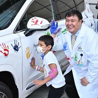 Dr. Steven Jonas and a patient at UCLA Mattel Children's Hospital put their handprints on a Hyundai during a celebration of Dr. Jonas receiving a $400,000 grant