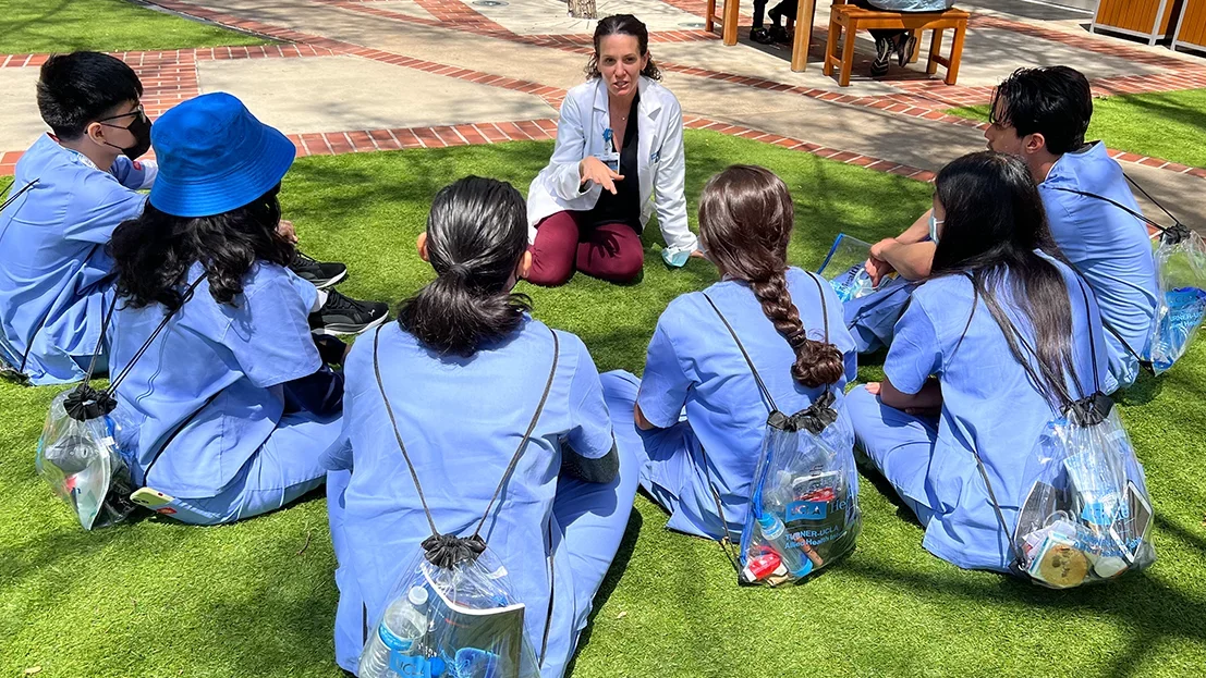 A group of students involved with community engagement in the courtyard beside Ronald Reagan Medical Center