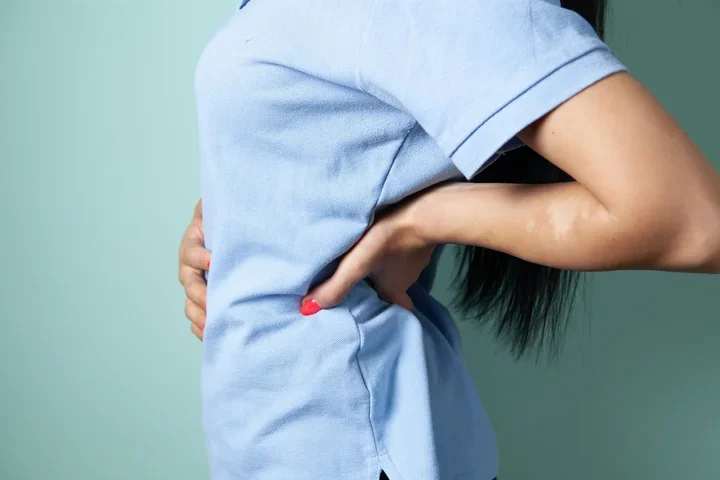 Woman braces back in pain
