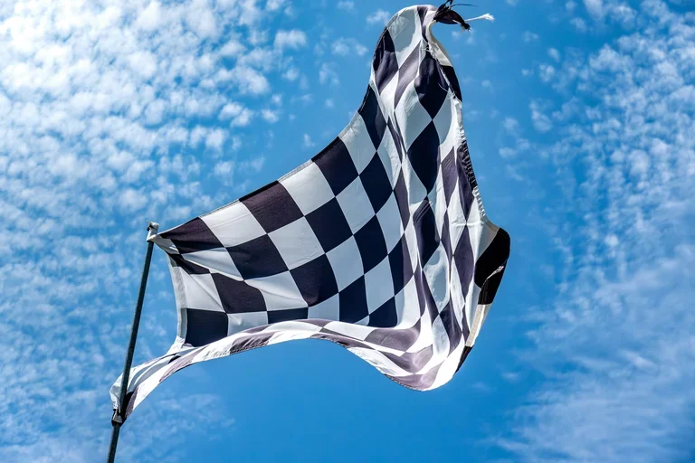 Checkered fag against a blue sky