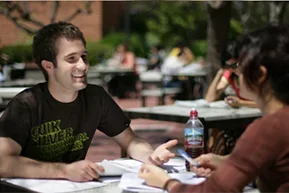 Two students at an outdoor table