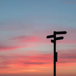 A crossroads sign at sunset